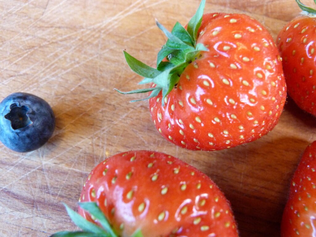 Two strawberries and one blueberry.