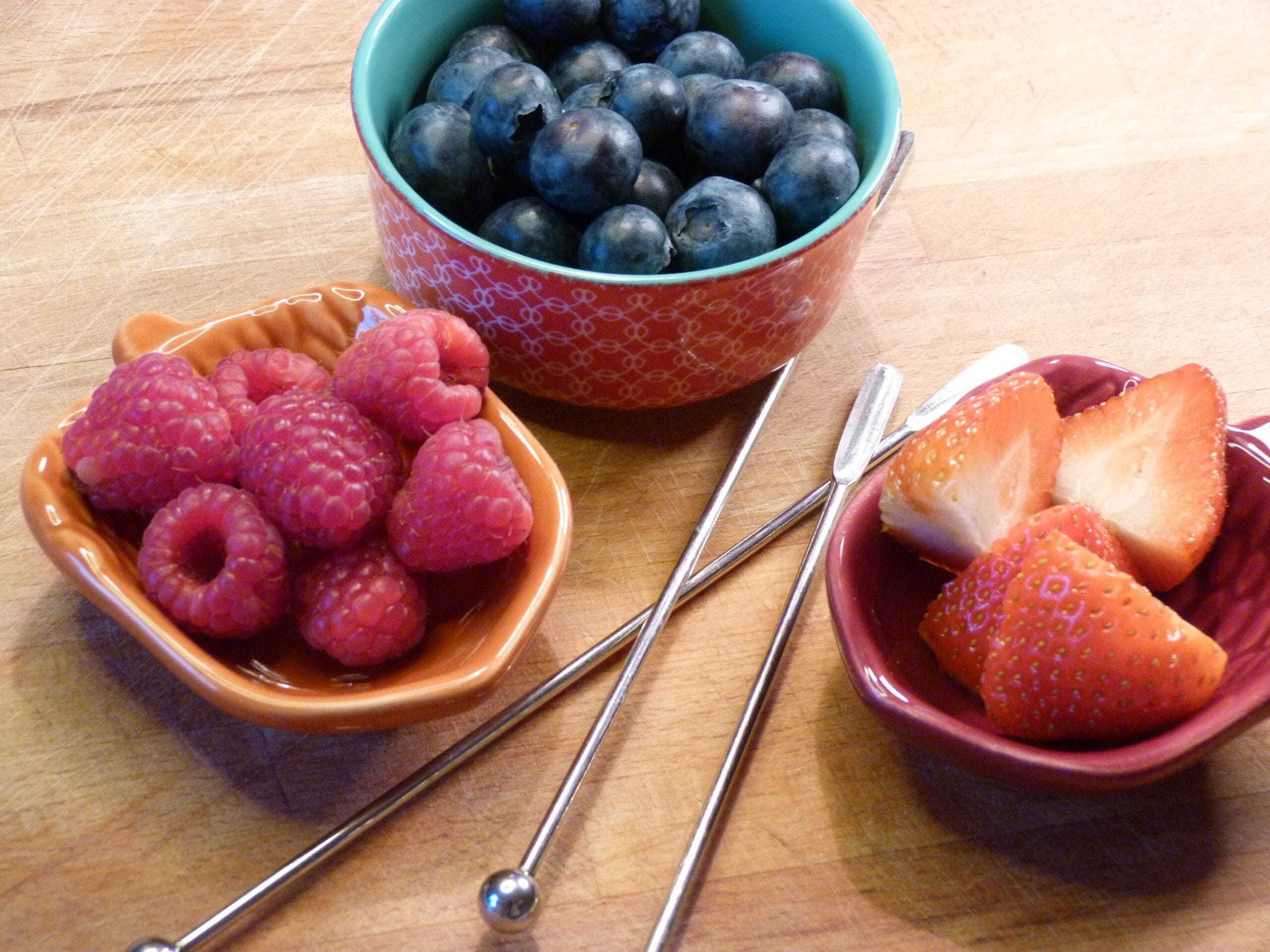 A child threading fruit onto a skewer, building fine motor strength and coordination
