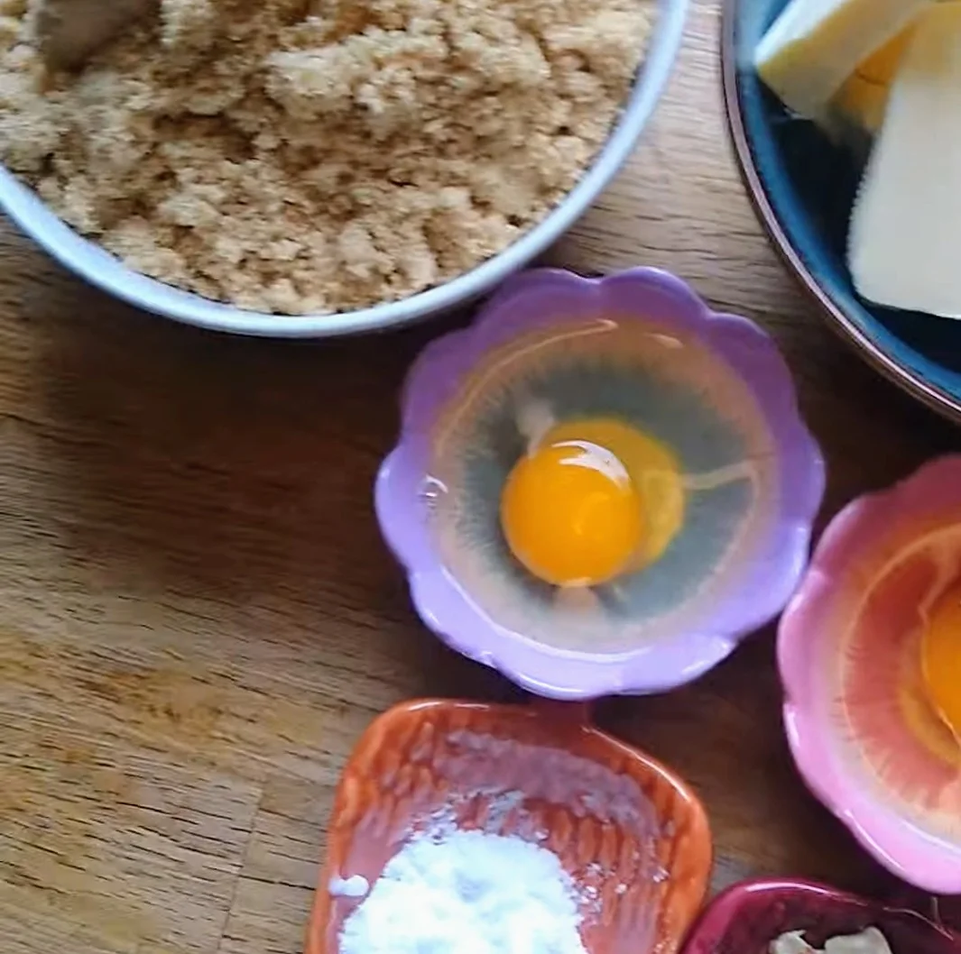Egg cracked in a purple bowl. How to Teach Your Child to Crack an Egg: Three Simple Steps
