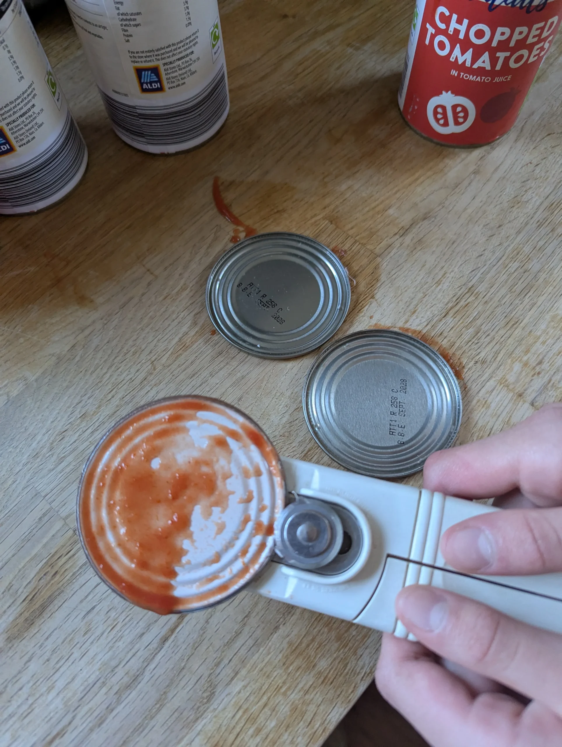 Close-up of the inside of an opened tomato tin showing the pink plastic coating