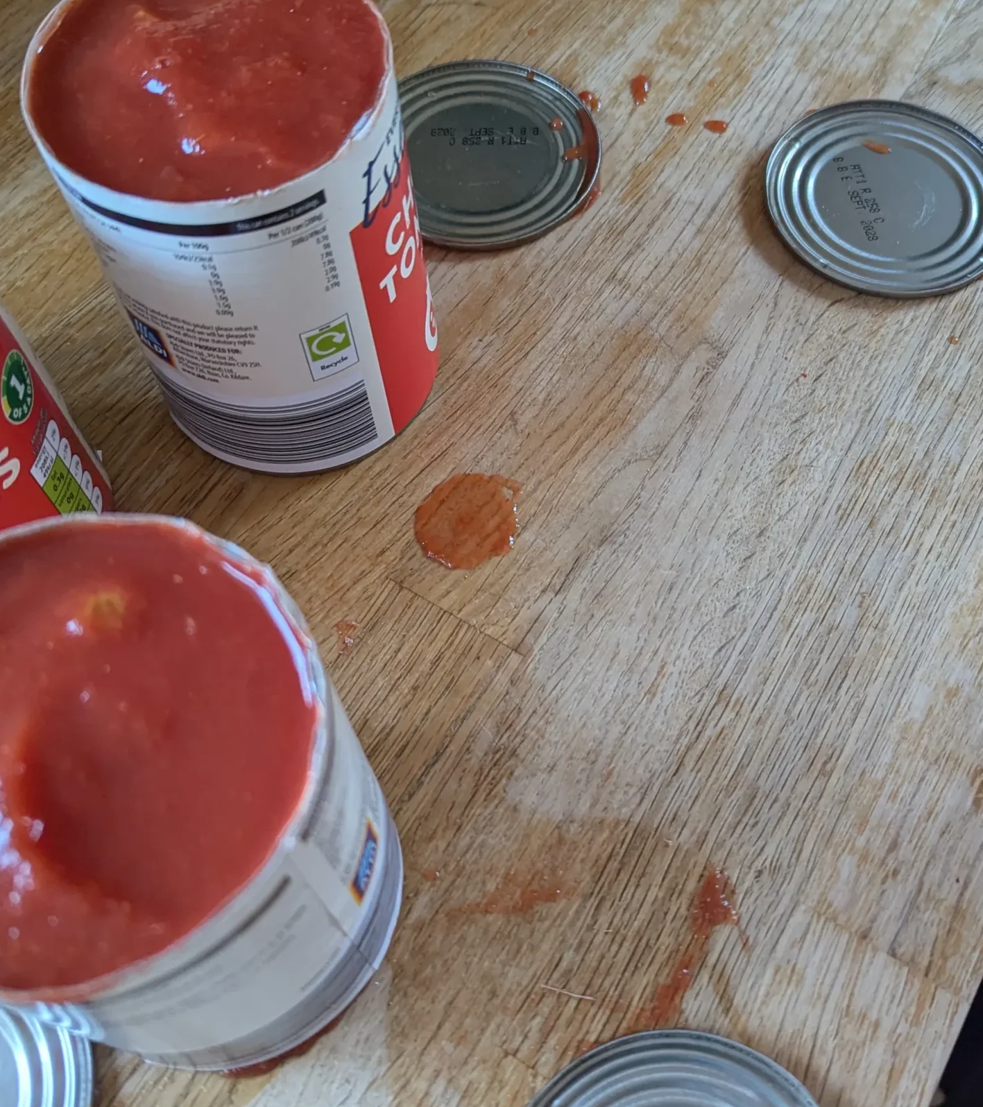 Top-down view of an open tin showing a perfect circle, with the lid placed beside it